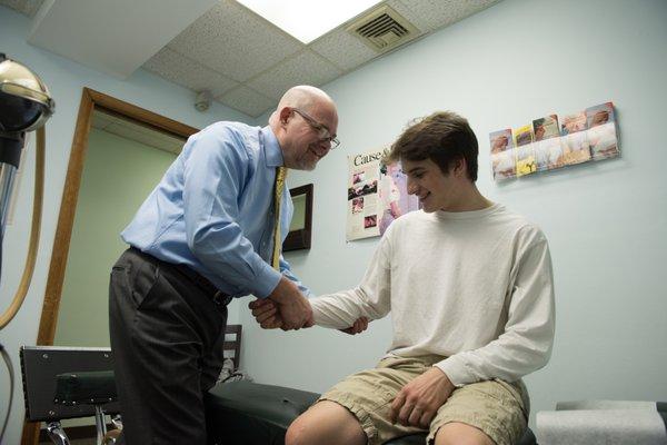 Dr. Brown is adjusting the elbow for a high school athelete.