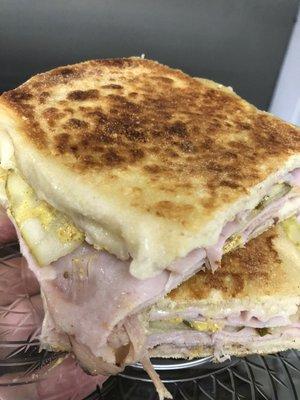 The Cuban-Grilled and toasty with layers of ham, roast pork and Swiss cheese finished with pickles and mustard!  Limited time only!