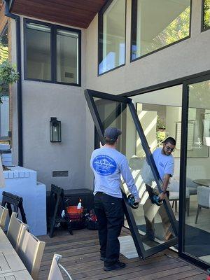 Gus and John getting ready to reinstall a sliding door panel. We changed the rollers and repaired the track.