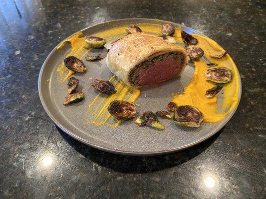 Beef Wellington with carrot purée and Brussels sprouts.