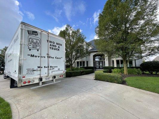 Two Men and A Truck moving truck outside a home.