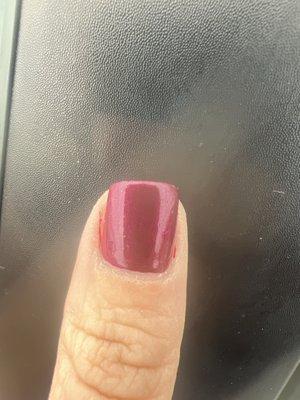 Polish on sides of fingertips and nail is filed crooked.