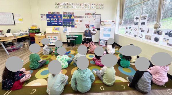 Circle time with a new theme every month. Th eyes her is very much in control of the room.