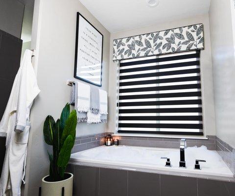 Black dual sheer shades and a patterned valance make this bathroom the perfect place to unwind!