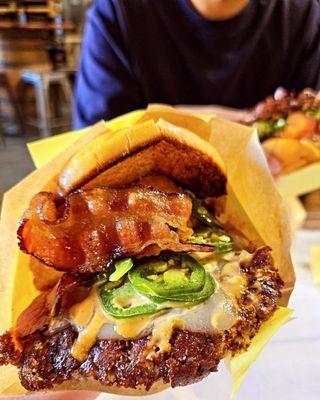 Hellapeño burger: 2 patties, pepperjack cheese, grilled onions, pork bacon, jalapeños, onion rings, smack sauce, mikes hot honey.