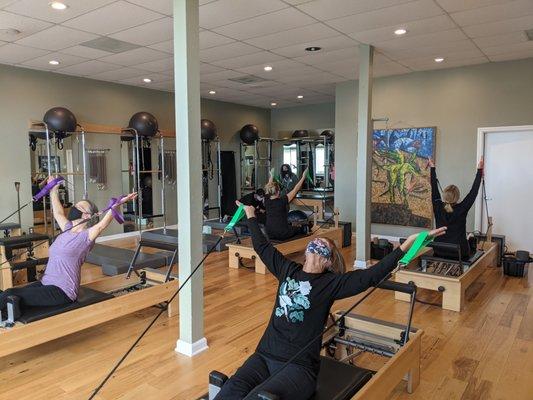 Semi-private Pilates classes use a variety of equipment and props including reformers.