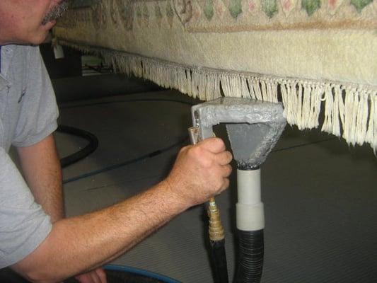 Hand cleaning fringe on an oriental rug in Northwest Indiana