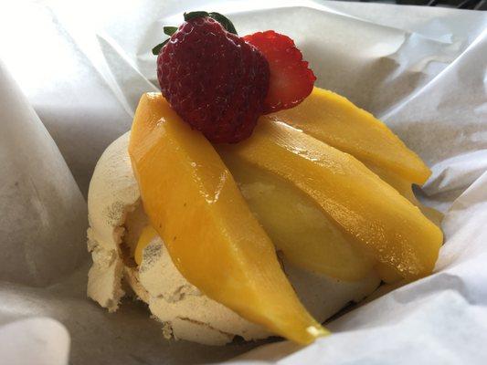 Single Pavlova, filled with a passionfruit curd, topped with mango and strawberries.