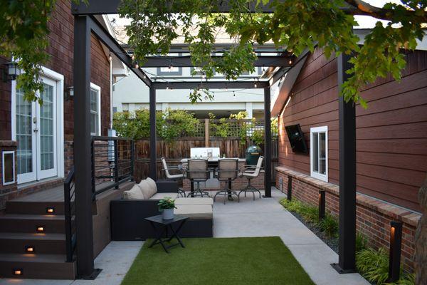 Wash Park outdoor living/dining area, including custom outdoor kitchen, steel pergola with retractable awning, high end landscape lighting.