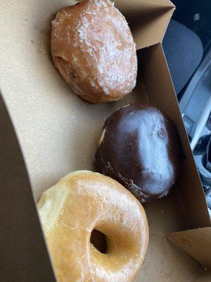 A glazed doughnut, a Boston cream, and a strawberry filled