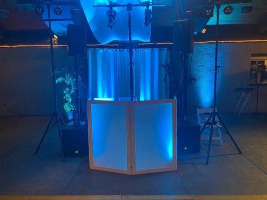 DJ booth at wedding with lighting to match wedding colors.