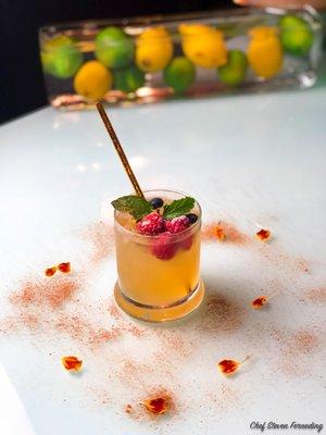 Apple Cider Vodka Cocktail with frozen berries and mint dusted with Vietnamese Cinnamon