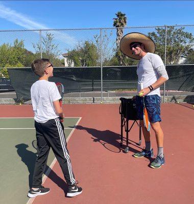 Coach Brandon and Stanley sharing a laugh during service practice