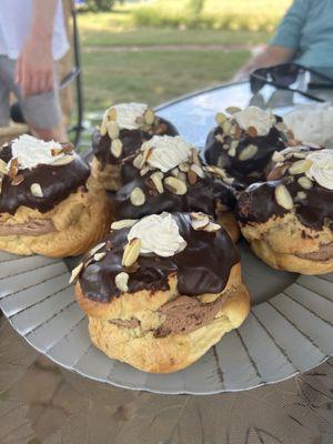 Giant cream puffs with milk chocolate filling, chocolate ganache, cut almonds on top