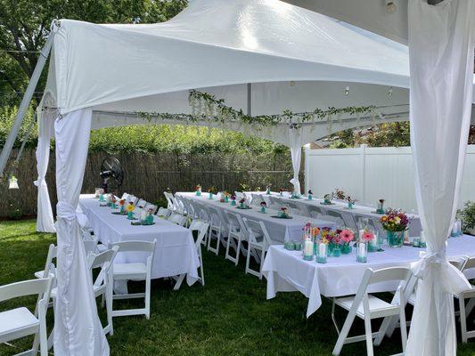 20x20 high peak wedding tent with garden chairs, pole drapes, and string lighting