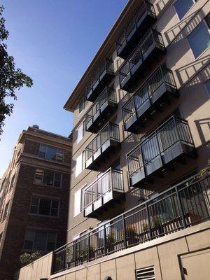 A view from the alley behind the building of some of the patios and terraces