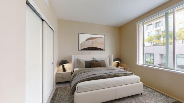 Staged bedroom featuring large windows.