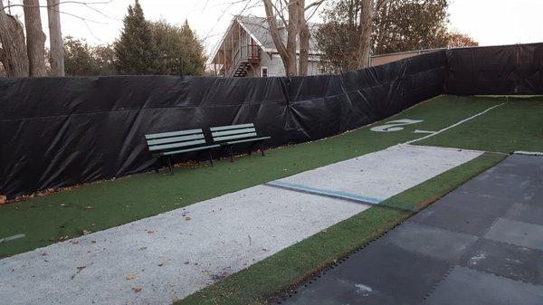 Fenced in outdoor space with real turf and privacy wind screen.