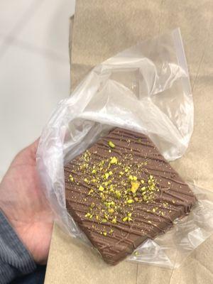 Dubai Chocolate, it has a pistachio cream w/ nuts and pastry bits inside. Displayed w/ a note "first come first serve"