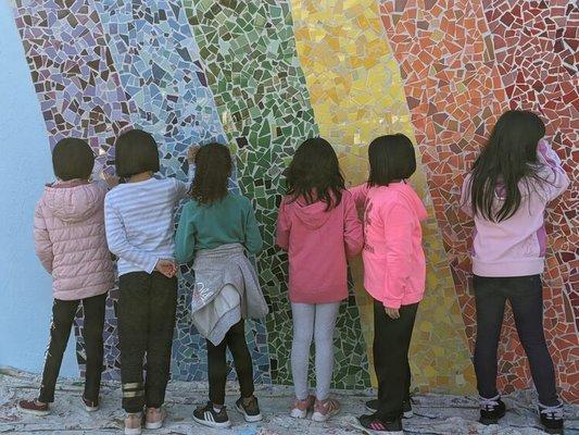 Students touching the rainbow in our beautiful new mural, spring 2020