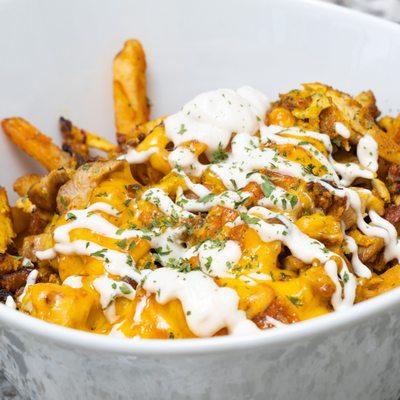 Shawarma Fries. Waffles fries, chicken shawarma, garlic sauce, and melted cheese