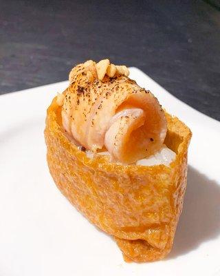 Tofu Skin with Torched Salmon Garlic. Inari (tofu skin) stuffed with sushi rice and torched salmon, sprinkled with crispy garlic⁣.⁣