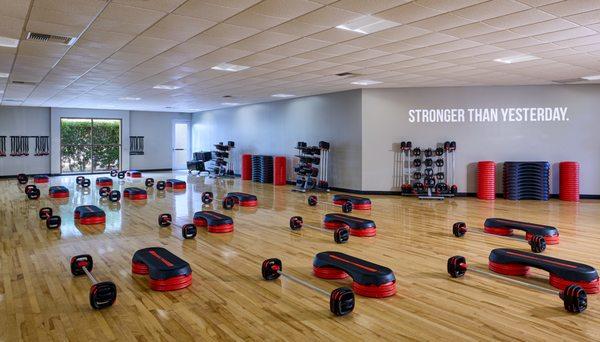 One of our group fitness studios set up for a BODYPUMP class using weighted barbells.