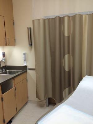 Exam room. Curtain over the door to the back hallway. Exam rooms have 2 entrances. One for staff and the other for the patient