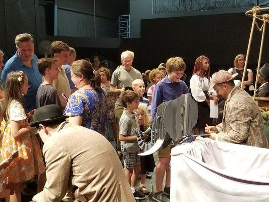 John Mayo and Ricky Rojas sign autographs for audience members after a performance of Around the World in Eighty Days.