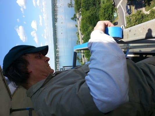 Here Ted applies the blue tape on the handrail of this terrace, preparing it for our pigeon repellent and Detour application.