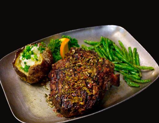 Bone-in steak with chimichurri, garlic seared green beans & a baked potato