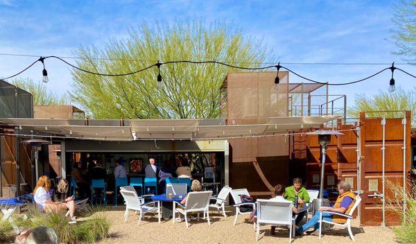 Great outdoor seating options. Private two-toppers are quaintly nestled in between the rusted steel panels on the right.