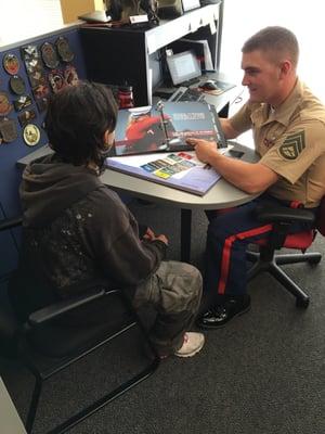 SSgt Brown utilizing photos of Marines and their families to show the pride family members have of their Marines.