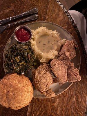 Fried chicken dinner with homemade biscuit, mashed potatoes, and greens