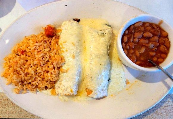 Mushroom and spinach enchiladas (lunch portion) with poblano sauce and sides of rice and charro beans