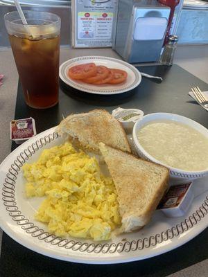 Scrambled eggs, toast, grits, tomatoes