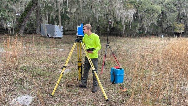 Dale S. using the robotic total station in order to take measurements of a building