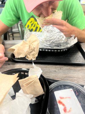 A very happy man chowing down on the Hula Burrito with some peach habanero salsa on top.