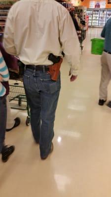 Guy with gun....wearing cowboy hat so no worries there! No need for you to bring a gun, because he has covered for you.