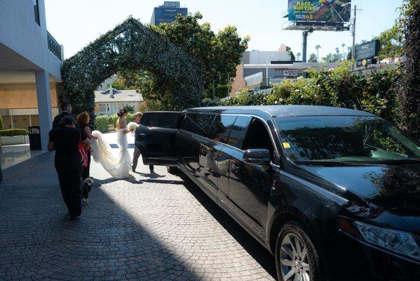 My spouse and I, our wedding assistant, dog and dog sitter getting into the car while the Riz Driver opens the door for us