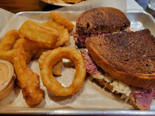 Rueben sandwich with onion rings.