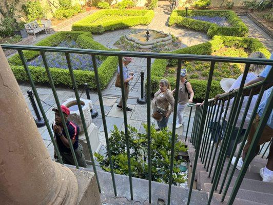 Tour guide to the left of picture and gardens in the back ground.