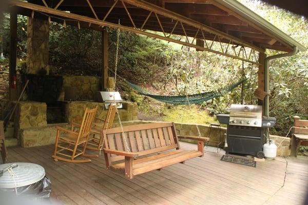 Covered area outdoor lounge and fire pit, gas and charcoal grills over looking the Estes Mill Creek.  Plenty of Adrionack chairs