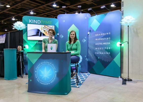 Bonnie & Bridget at a cannabis industry event. Trade show display was designed in house. Booth design is another service we offer clients.