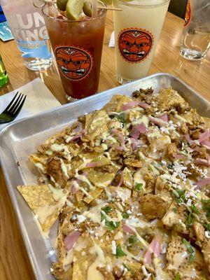 Full sheet chicken nachos with a couple of cocktails