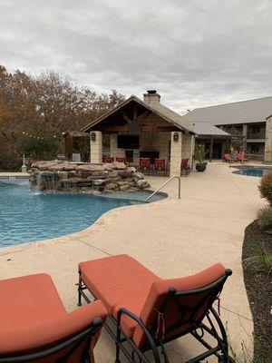 Really nice pool area with hot tub and 70 inch TV screen scene in the distance.