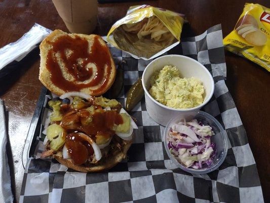 Pulled pork sandwich with potatoe salad and coleslaw/chips