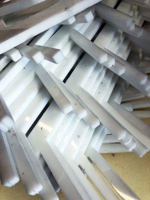 white .5" PVC / polypropylene brackets. This type of material is easily cut but also easily damaged by blow back from the waterjet.