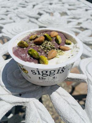 Blueberry banana peach smoothie added to Siggi's topped with hemp seeds, apricot seeds, pistachios