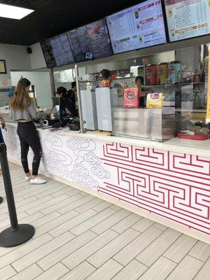 Ordering area with nicely displayed digital menus. Little eating area with booths and table/chairs off to the side.